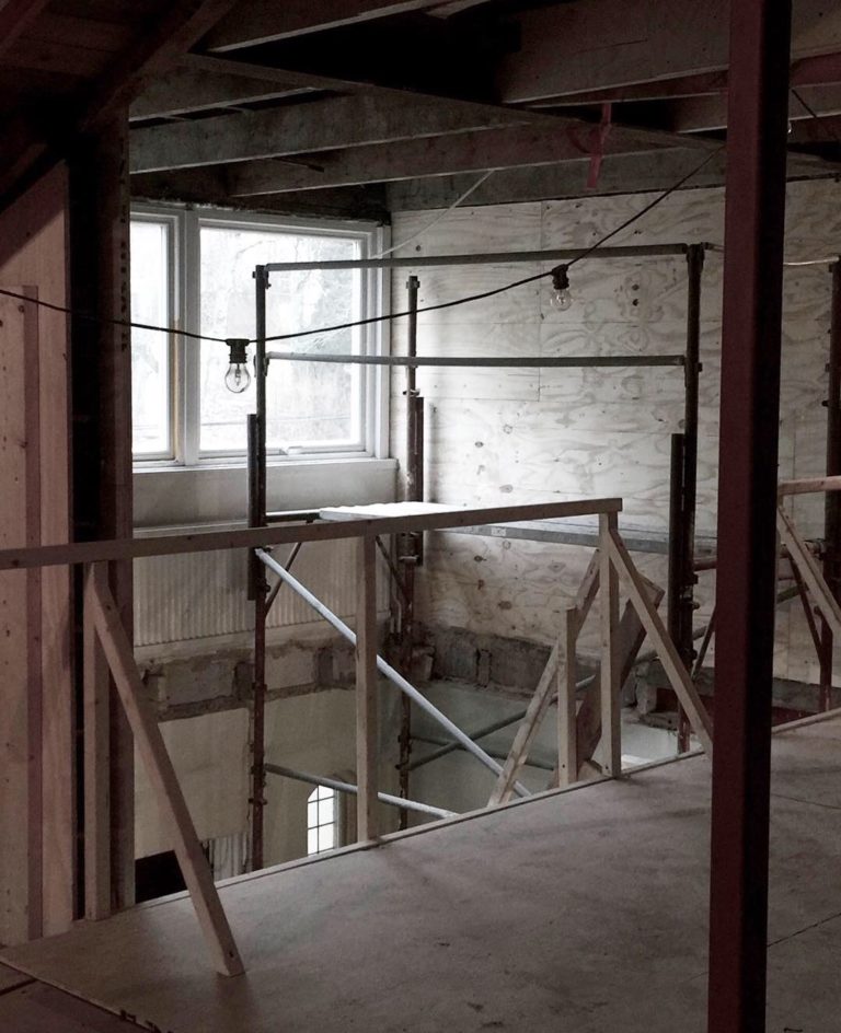 Pågående renovering av ett 60-talshus i Stockholm, med synliga byggställningar och provisorisk belysning, där en referenskund har fått professionell belysningskonsultation för att optimera ljusdesignen.